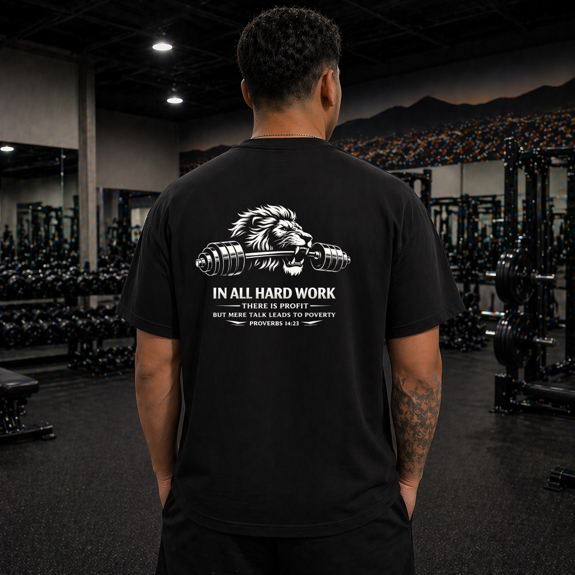 Person wearing a black t-shirt with a lion graphic and text in a gym setting